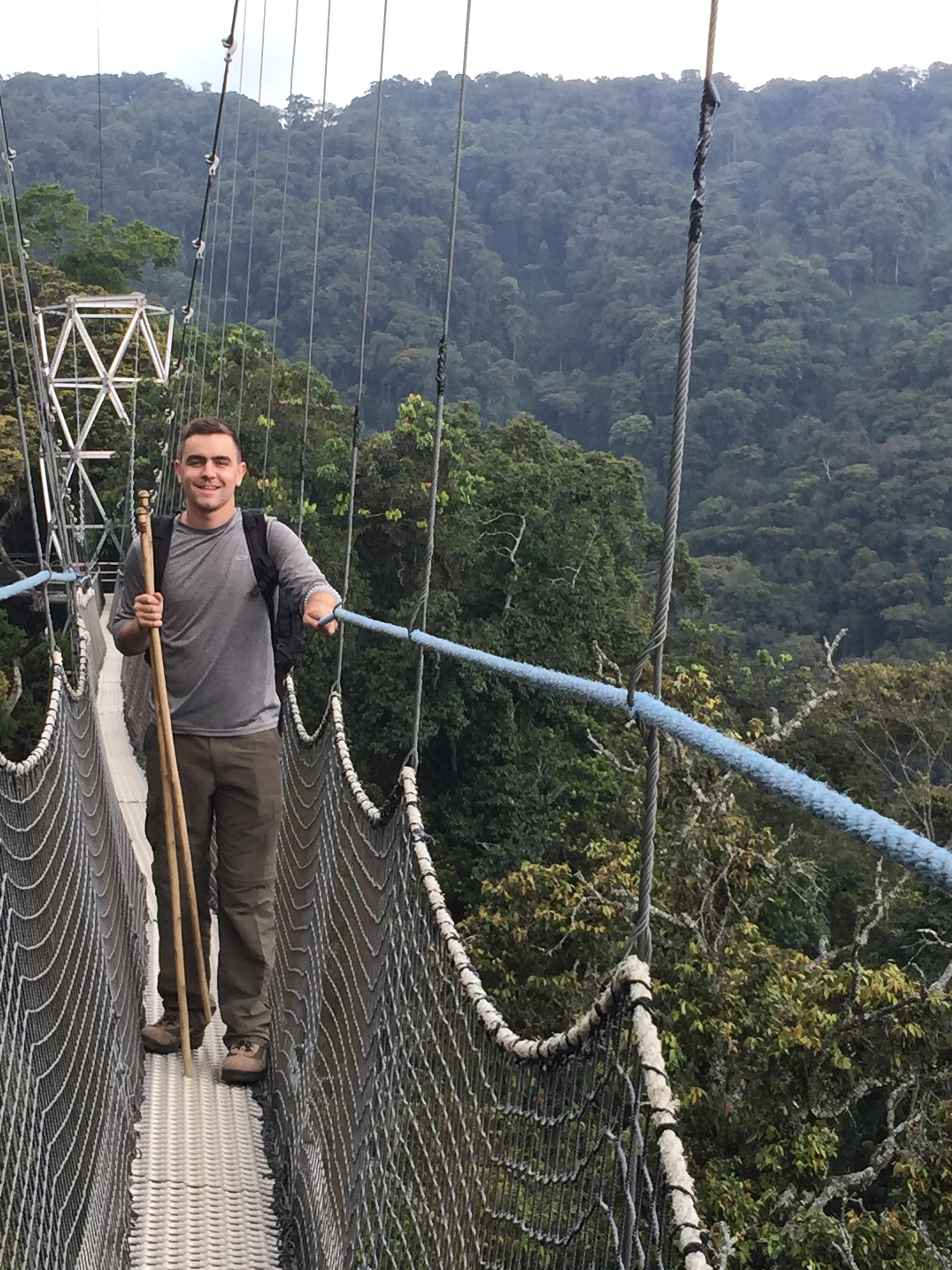 Adam hiking over a bridge